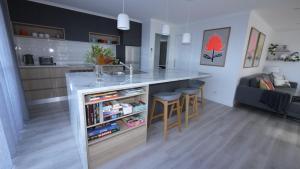 a kitchen and living room with a counter and stools at Stylish Holiday Unit in Bridport