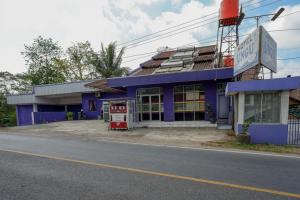 ein blaues Gebäude mit einer Tankstelle an der Straßenseite in der Unterkunft RedDoorz near RSUD Kebumen in Kebumen