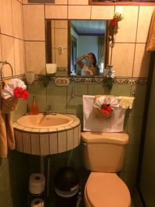 mężczyzna robiący zdjęcie łazienki z toaletą i umywalką w obiekcie Villa Guarias w mieście Puntarenas