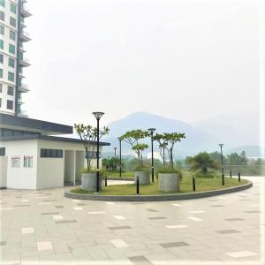 a courtyard with trees and street lights in front of a building at Lvl 22 City Park View 3BR Full Aircond with Pool at Casa Kayangan Meru in Ipoh