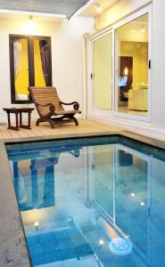 a bench sitting next to a swimming pool at Maya Kori Villa in Jimbaran