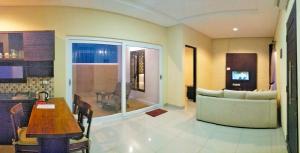 a living room with a couch and a table in a room at Maya Kori Villa in Jimbaran