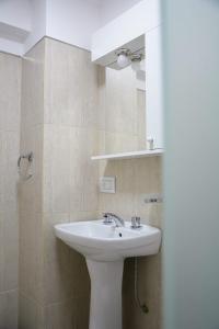 y baño con lavabo blanco y espejo. en Petit Apart Villa Regina en Villa Regina