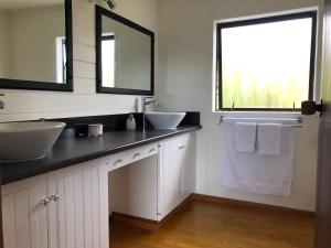 a bathroom with two sinks and a large window at Harbour View Retreat Mangonui in Mangonui