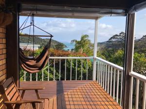 a hammock on a porch with a view of the ocean at Harbour View Retreat Mangonui in Mangonui