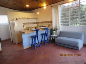 uma cozinha com bancos azuis e um balcão com um frigorífico em Casa rural tipo loft em Guatavita