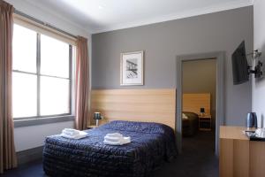Un pat sau paturi într-o cameră la Royal Exhibition Hotel