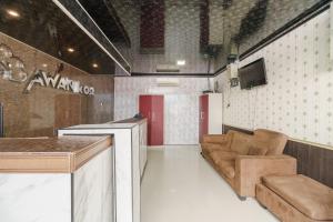 a room with a bar and a couch and a tv at RedDoorz Plus near Palembang Icon Mall 2 in Palembang