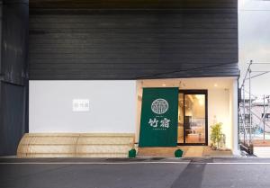 ein Gebäude mit einem grünen Schild an der Seite in der Unterkunft Hostel Takeyado in Osaka