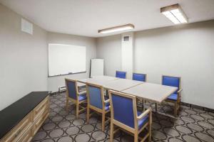 une salle de conférence avec une table, des chaises et un tableau blanc dans l'établissement Comfort Inn West, à Edmonton