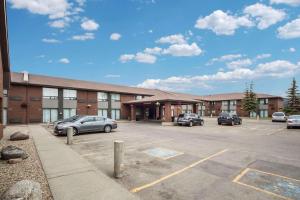 a building with cars parked in a parking lot at Comfort Inn West in Edmonton