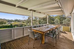 een terras met een houten tafel en stoelen bij Ellis Cottage Sorrento plus Guest House in Sorrento