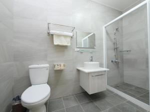 a bathroom with a toilet and a shower and a sink at Hengchun Inn in Hengchun