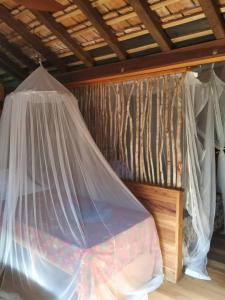 a bed with a mosquito net in a room at Tevana House Reef in Bira