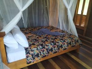 a bed in a room with a canopy at Tevana House Reef in Bira