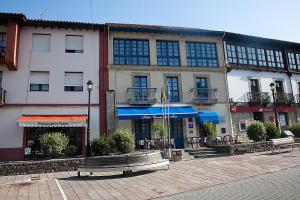 un edificio con un banco delante de él en Hotel Cuevas Del Mar en Nueva de Llanes