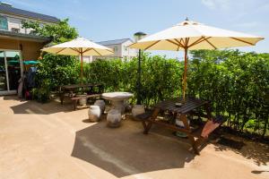 a patio with a table and an umbrella and benches at Backpacker B&B in Jinning