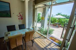 金寧鄉的住宿－小背包民宿，一间带玻璃桌的用餐室和一个阳台