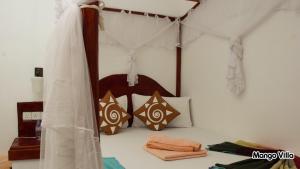 una camera da letto con un letto a baldacchino di Mango Villa Sigiriya a Sigiriya