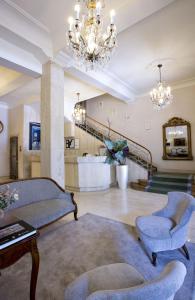 a living room with a couch and chairs and a chandelier at Hotel Niza in Donostia-San Sebastián