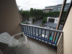 d'un balcon avec une chaise et une vue sur la rue. dans l'établissement Sleepwell@naiyang, à Nai Yang Beach
