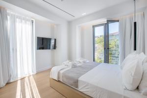 a white bedroom with a bed and a large window at Nsplace in Athens