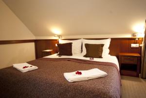 Una habitación de hotel con una cama con dos toallas. en Trifecta Udvarház, en Tállya