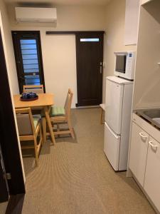 a small kitchen with a table and a refrigerator at 明和荘Mei Wa Inn in Kyoto