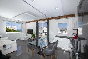 a kitchen and living room with a glass table and chairs at Zannis Hotel in M&yacute;konos City