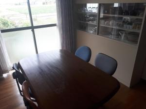 a wooden table and chairs in a room with a window at Hostel Amaou in Oki