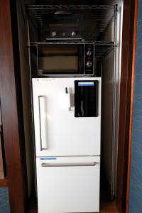 a refrigerator with a microwave on top of it at Guesthouse Iwase in Toyama