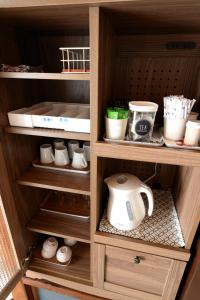 a wooden cabinet with a tea kettle in it at Guesthouse Iwase in Toyama