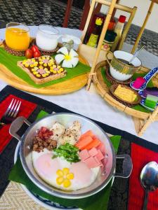 - une table avec un bol de nourriture et une assiette de nourriture dans l'établissement Baan Sithepaban Guesthouse, à Phitsanulok