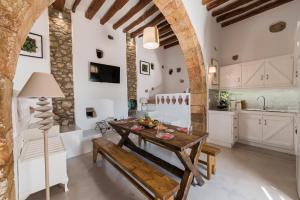 a kitchen and dining room with a wooden table and bench at Casa Blue in Gennadi