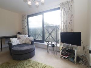 a living room with a chair and a large window at Flat 2 in Street