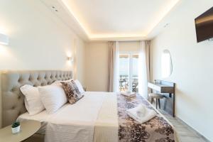 a bedroom with a bed with a view of the ocean at Luxury Plateia Rooms in Perea