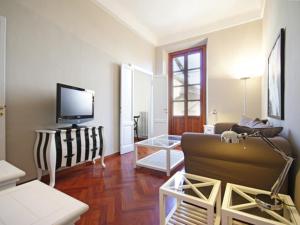ein Wohnzimmer mit einem Sofa und einem TV in der Unterkunft Mercalli 1 in Mailand