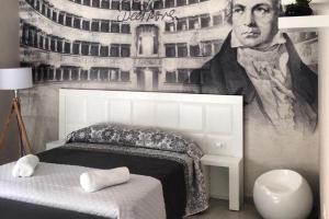 un dormitorio con un retrato de un hombre en la pared en Al Giordano, en Foggia