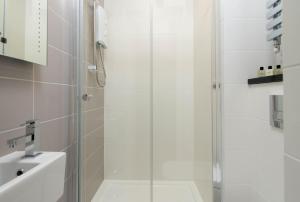 a shower with a glass door next to a sink at Mulberry Flat 2 - Two bedroom 1st floor by City Living London in London