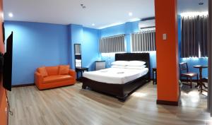 um quarto com uma cama e uma cadeira laranja em One Averee Bay Hotel em Coron