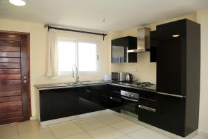 a kitchen with black cabinets and a sink and a window at Executive Suites in Kigali