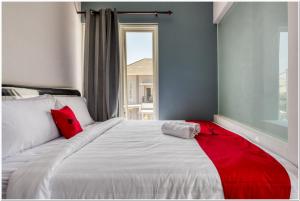 een slaapkamer met een wit bed met een rode deken erop bij RedDoorz @ Bypass Juanda Airport in Sidoarjo