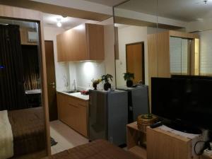 una cucina con frigorifero e TV di Pleasant@tifolia , 1br, New Room In Kelapa Gading a Giacarta