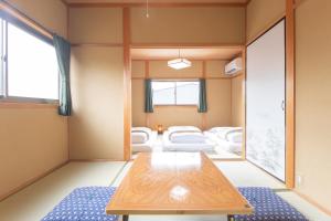 una camera con un tavolo e alcuni letti all'interno di Yachiyo - モトオコノミヤキヤ - BBQ OK & Pet Friendly - Self Check-In Only a Uda