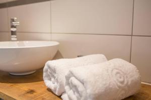 a bathroom with a white sink and towels on a counter at Victoire Duplex atypique cosy - PLEIN CENTRE HISTORIQUE BAYEUX PROCHE RESTAURANTS COMMERCES- LUMINEUX - PARKING GRATUIT A PROXIMITE- proche plages du débarquement, Omaha Beach in Bayeux +57 photos