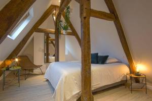 a bedroom with a white bed in a attic at Victoire Duplex atypique cosy - PLEIN CENTRE HISTORIQUE BAYEUX PROCHE RESTAURANTS COMMERCES- LUMINEUX - PARKING GRATUIT A PROXIMITE- proche plages du débarquement, Omaha Beach in Bayeux