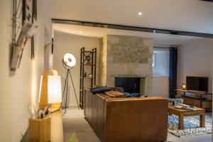 a living room with a couch and a fireplace at Victoire Duplex atypique cosy - PLEIN CENTRE HISTORIQUE BAYEUX PROCHE RESTAURANTS COMMERCES- LUMINEUX - PARKING GRATUIT A PROXIMITE- proche plages du débarquement, Omaha Beach in Bayeux