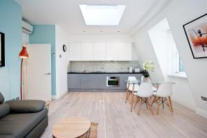 a living room with a couch and a table at Interlude House E Penthouse by City Living London in London