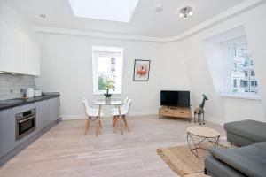 Il comprend une cuisine et un salon avec une table et des chaises. dans l'établissement Interlude House E Penthouse by City Living London, à Londres