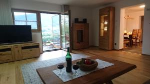 a living room with a table and a bottle of wine at Teisenbergblick in Gschwend